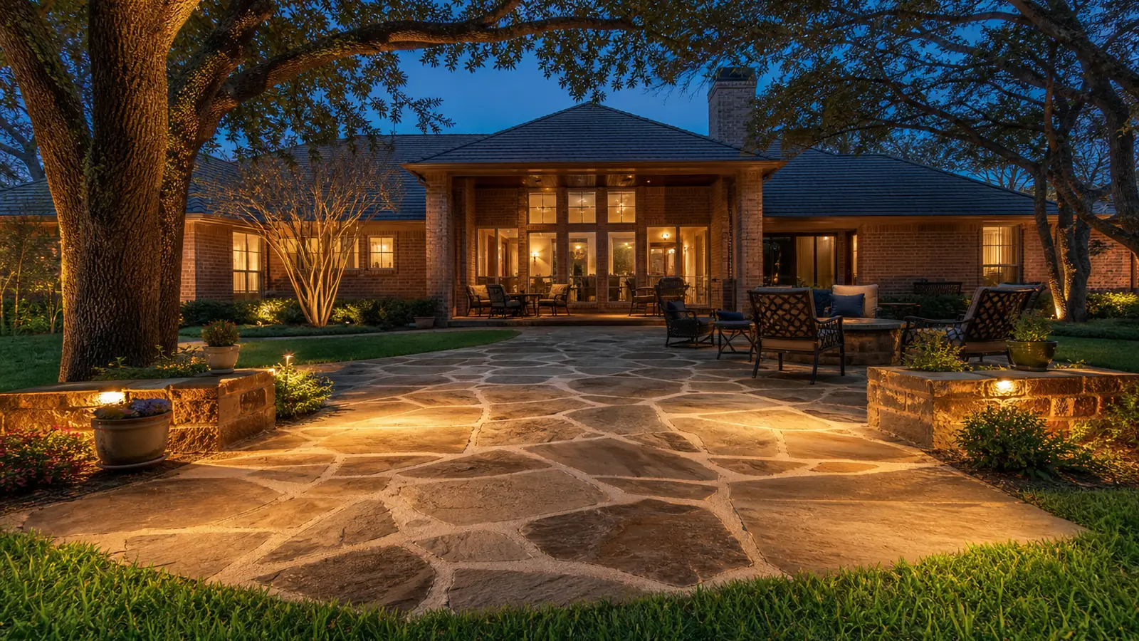 Flagstone patio with landscape lighting at dusk in a Colleyville TX back yard